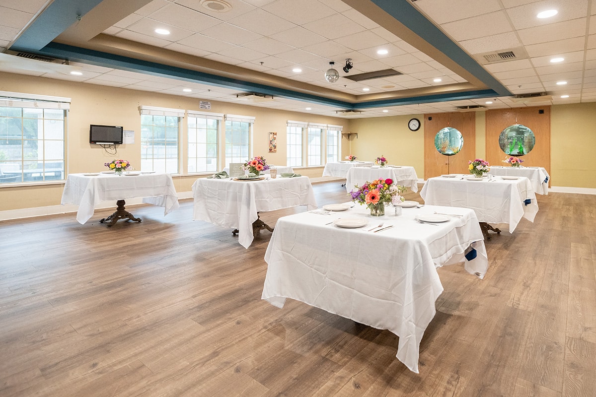 Spacious dining area with flower centerpieces at Arbor Post Acute.