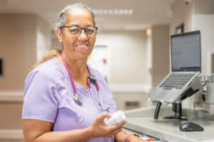 a nurse at a nurse's cart in the hallway at Arbor Post Acute