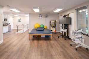 Rehab gym with therapy table and exercise equipment at Arbor Post-Acute.