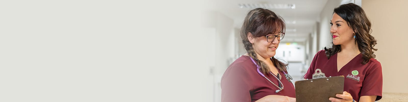 two nurses talking in the hallway at Arbor Post Acute